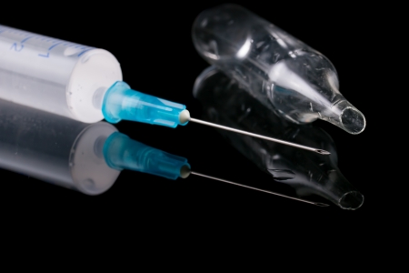 Medical syringe and glass vial on a black background の写真素材