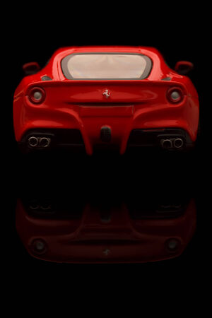 KRIVOY ROG, UKRAINE - JAN 04 - Toy ferrari F12 berlinetta on black   backgrond, Saturday 4 January 2014のeditorial素材