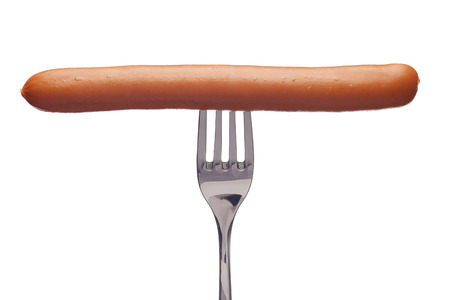 Tasty sausage on a silver fork on a white background.の写真素材