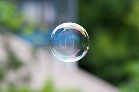 Soap ball in daylight against a background of greenery.の写真素材