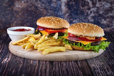Photo of delicious burgers with fries with ketchup on a beautiful background.の写真素材