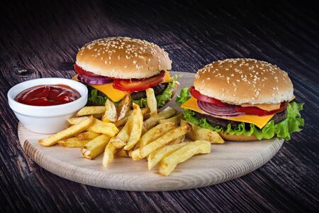Photo of delicious burgers with fries with ketchup on a beautiful background.の写真素材