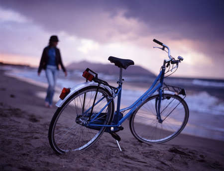bicycle on the beach near sea in the eveningの写真素材