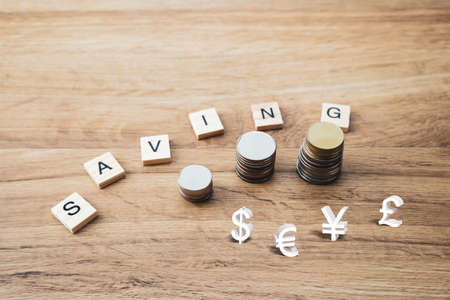 Saving concept of financial improvement progress by stack of coin or cash growing on wooden background. Rising of graph or tree on money show for treasure and wealth of growth economy.の写真素材