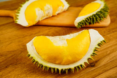 Closeup durian fruit peel in half on wooden table background. A smelly tropical seasonal fruit of Asia. The most tasty king fruit very popular in Thailand due to its freshness, sweet and delicious.の写真素材