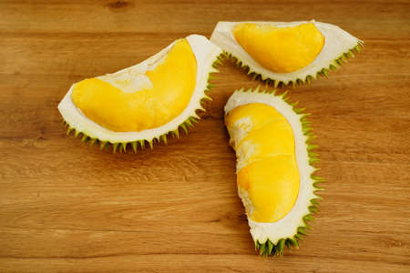 Closeup durian fruit peel in half on wooden table background. A smelly tropical seasonal fruit of Asia. The most tasty king fruit very popular in Thailand due to its freshness, sweet and delicious.の写真素材