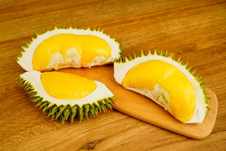 Closeup durian fruit peel in half on wooden table background. A smelly tropical seasonal fruit of Asia. The most tasty king fruit very popular in Thailand due to its freshness, sweet and delicious.の写真素材