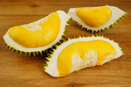 Closeup durian fruit peel in half on wooden table background. A smelly tropical seasonal fruit of Asia. The most tasty king fruit very popular in Thailand due to its freshness, sweet and delicious.の写真素材