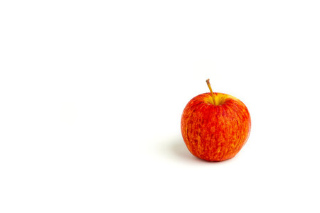 Hand hold red, yellow apple cutout on isolated white background. This juicy healthy fruit is very tasty and has natural vitamin with antioxidant nutrition. Eat as health and diet food.の写真素材