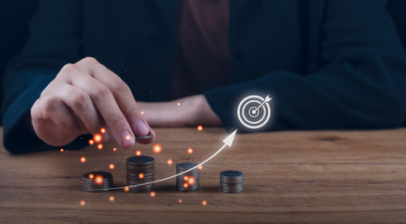 Savings and Investment concept. Finance accounting to arrange coins into growing graphs. businessman holding a coin putting on stack coins growing for business.の写真素材