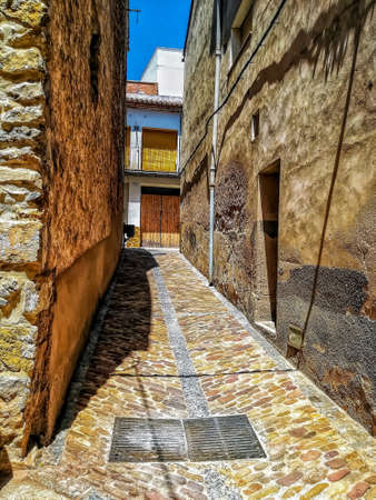 Narrow alley with soil and stone housesの写真素材