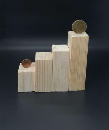 Wooden blocks on staircase with coins on black background