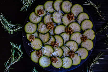 Carpaccio of zucchini with nuts and cheese on dark wooden backgroundの写真素材