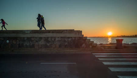 Burriana, Spain 12/06/18: Family strolling by jetty at sunsetのeditorial素材