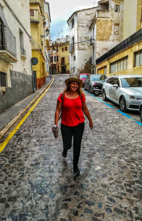 Woman with a hat walking through the streets of Segorbeのeditorial素材