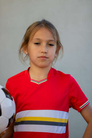 Little girl posing with football player luggageの写真素材