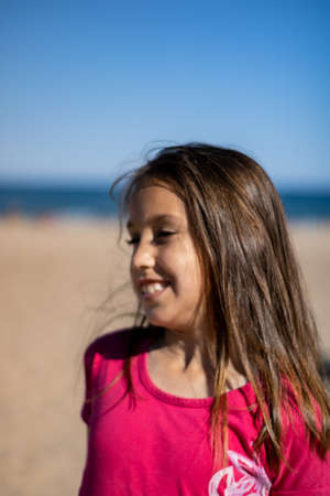 Little girl posing on the beach with the Mediterranean Sea in the backgroundの写真素材