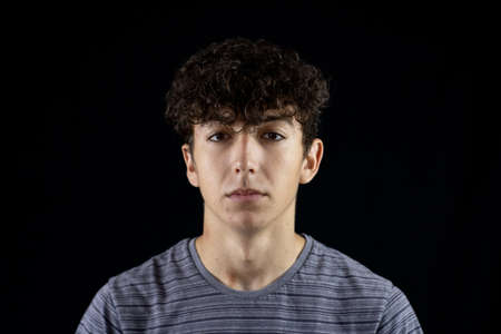 Portrait of young boy on a black backgroundの写真素材