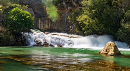 Small waterfall on the Mijares river in long exposure as it passes through Montanejos