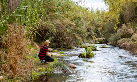 Man hiking along the bank of a river