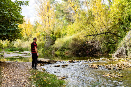Man hiking along the bank of a riverの写真素材