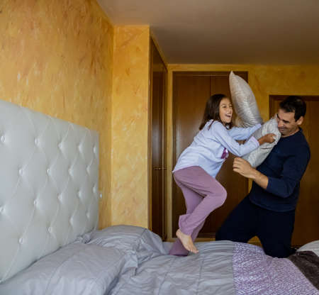 Father and daughter playing pillow fightsの写真素材