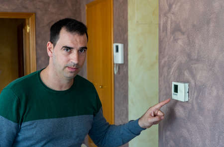 Man starting up the heating at home