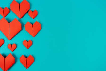 Origami hearts made of paper on blue backgroundの写真素材