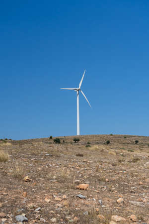 Mountainous landscape with wind energy mills mixing rural life with renewable technologies. Healthy...