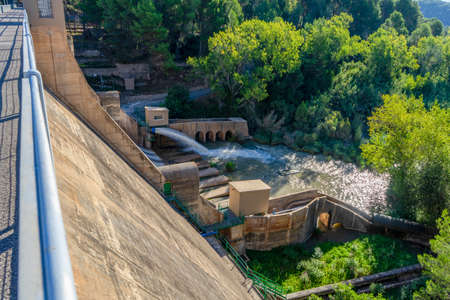 View of the Regajo reservoir dam with a stream of water surrounded by pine forests. Architecture conceptの写真素材