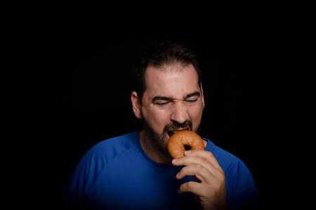 Bearded man dressed in blue t-shirt posing against black background. Fashion conceptの写真素材