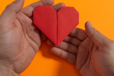 Origami hearts made with colored paper for congratulations on Valentine's Day for couples in love, on yellow background. Love conceptの写真素材