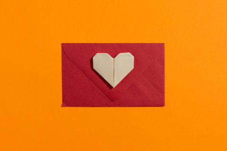 Origami hearts made with colored paper for congratulations on Valentine's Day for couples in love, on yellow background. Love conceptの写真素材