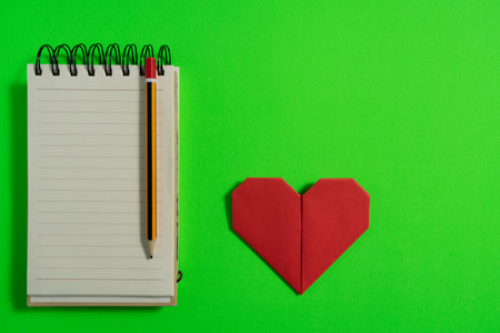 Origami hearts made with colored paper for congratulations on Valentine's Day for couples in love, on green background. Love conceptの写真素材