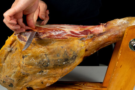 Detail of ham placed in a wooden ham holder ready to be cut. Exquisite food. Spanish tradition. Feeding conceptの写真素材