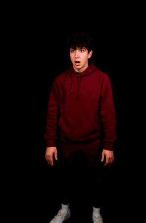 Attractive young man with curly hair posing on black background. Fashion conceptの写真素材