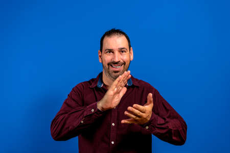Young handsome man feeling happy and successful, smiling and clapping hands, saying congratulations...