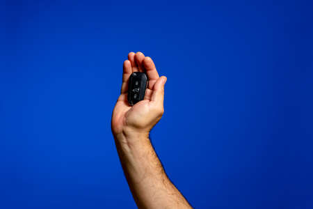 A man holding a car key on isolated background and clipping pathの写真素材