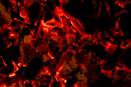 Glowing embers in hot red color, abstract background. The hot embers of burning wood log fire....