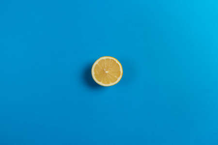 Top view of half a lemon isolated on a blue background, citrus fruit with a lot of vitamin c.の写真素材
