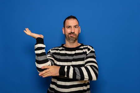 Caucasian handsome man holding an imaginary copy space on the palm of his hand to insert an ad over...