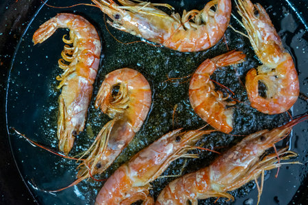 Top view of a traditional frying pan with large fresh prawns, delicious delicacy typical of the...