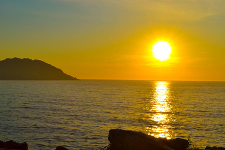 Background of colorful sky concept: beautiful sunset over the sea and rocksの写真素材