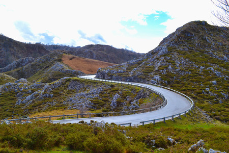 Curved asphalt road in middle of a rocky mountain. Dangerous s-shaped wayの写真素材