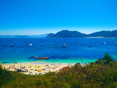 Beach of Cies Islands, in Galicia, Spain, with boats docked in front ofのeditorial素材