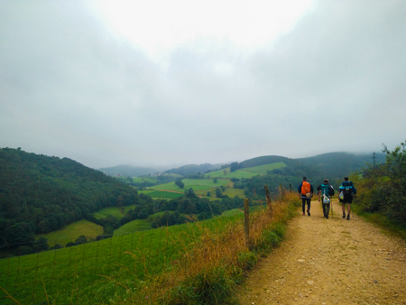 Pilgrims walking through a way in middle of the farmland in a foggy day in Asturias, Spain. Camino de Santiago Primitivoのeditorial素材