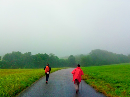 Pilgrims walking through a way in middle of the farmland in a foggy day in Asturias, Spain. Camino de Santiago Primitivoのeditorial素材