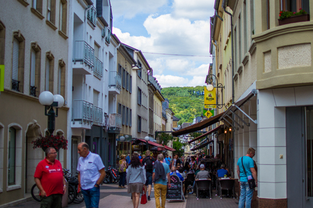 Echternach, Luxembourg; 08/11/2018: Narrow street in old town of Echternach, in Luxembourg, Europe. Typical houses with flags and tourists walking.のeditorial素材