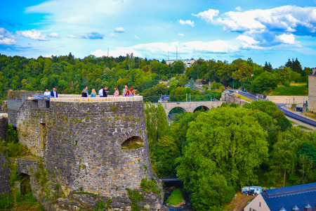 Tower of the wall of old town of Luxembourg City, Luxembourg, with people on it and green treesのeditorial素材
