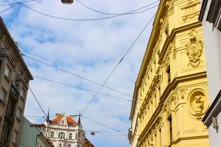Facade of a typical colorful classic building in a street with electricity cables of the tram, in...
